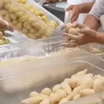 Homem preparando massa de coxinha congelada para vender,